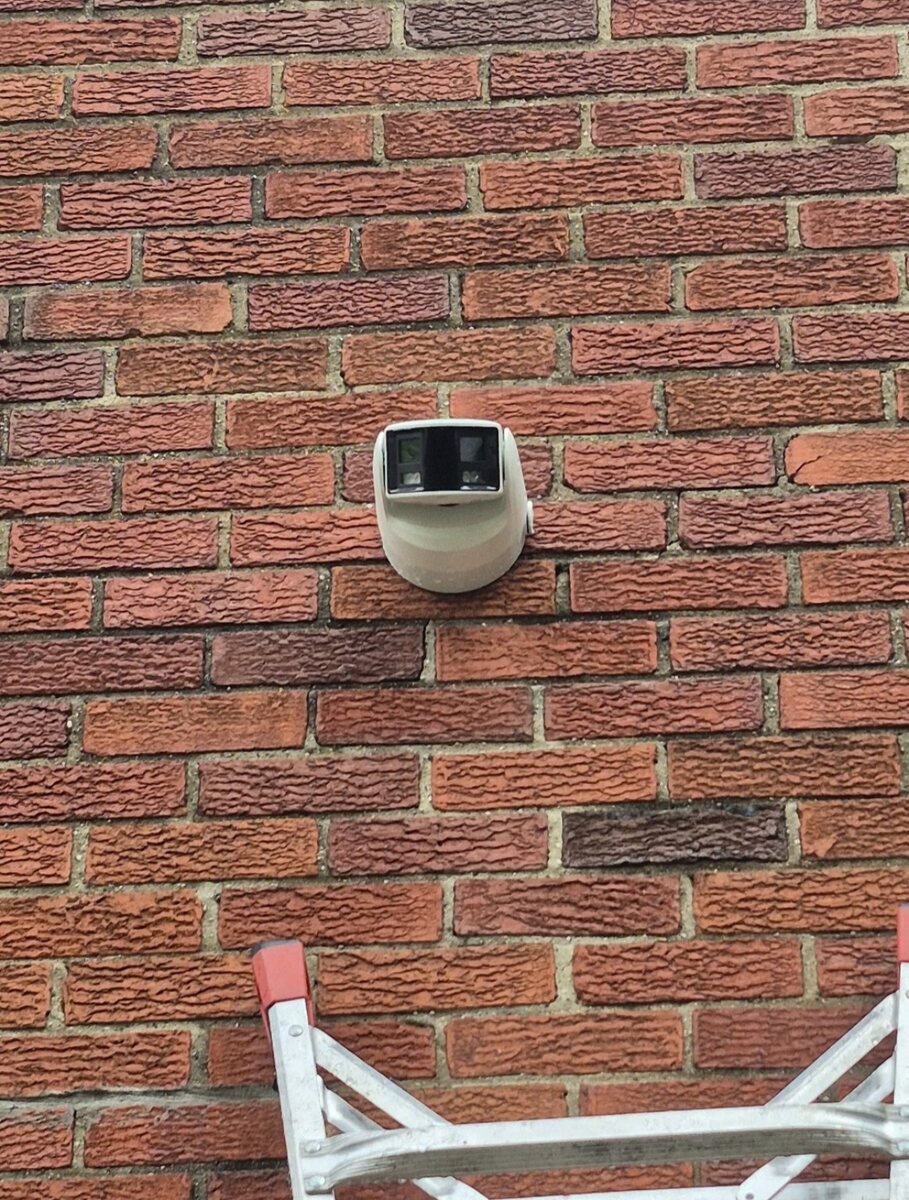 Clean exterior security camera installation on a brick wall